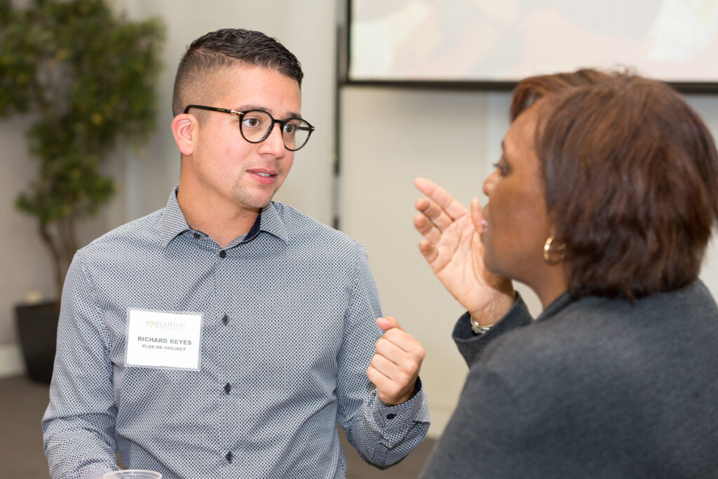 man in glasses having conversation with woman at event